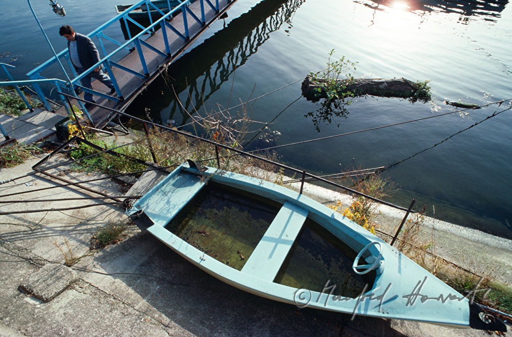 Steg zu verankertem Schiff und Ruderboot
