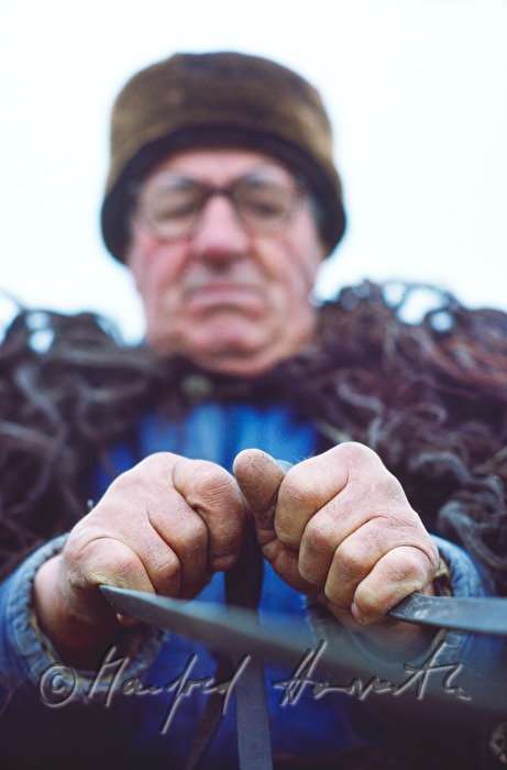 Bauer mit Pferdefuhrwerk und Fellumhang
