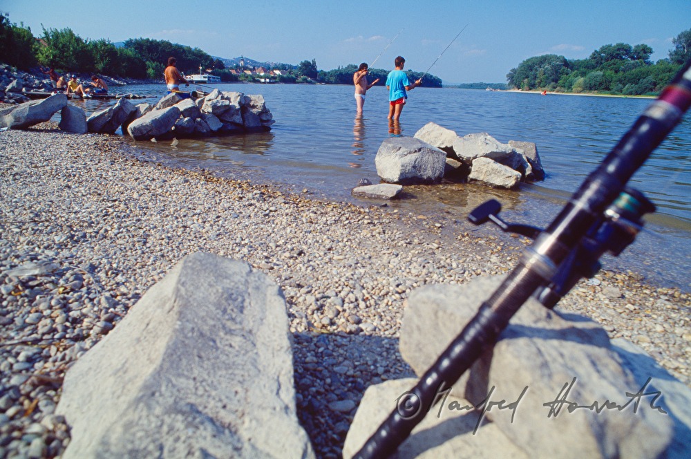 Fischer und Badende am Ufer der Donau