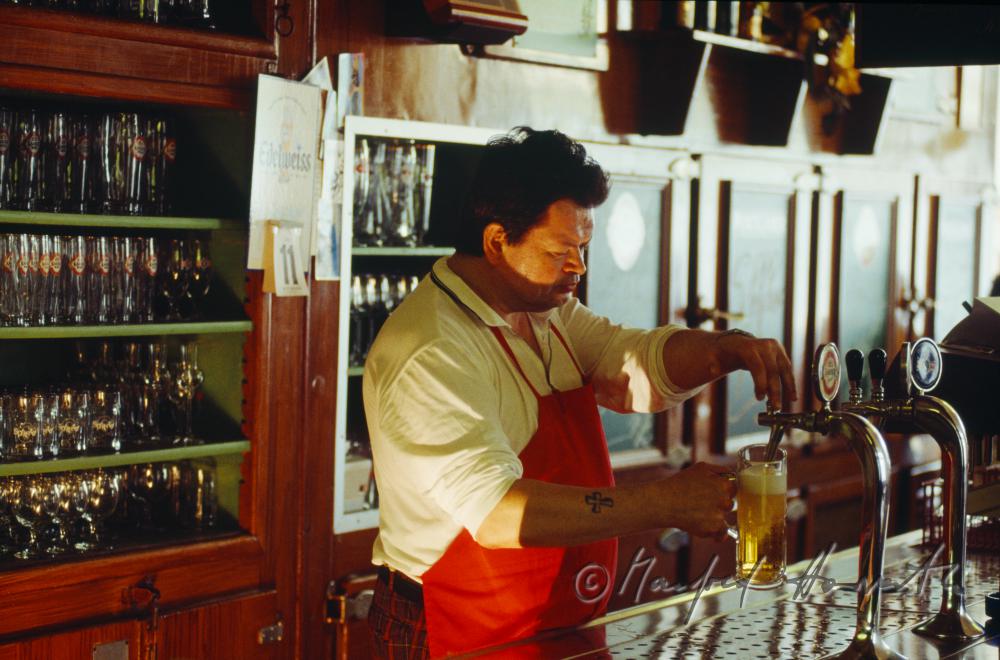 Kellner zapft Bier an der Theke