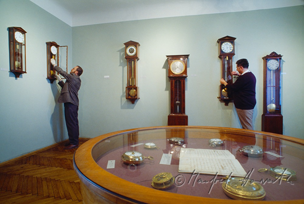 Direktor Rupert Kerschbaum öffnet eine Wanduhr