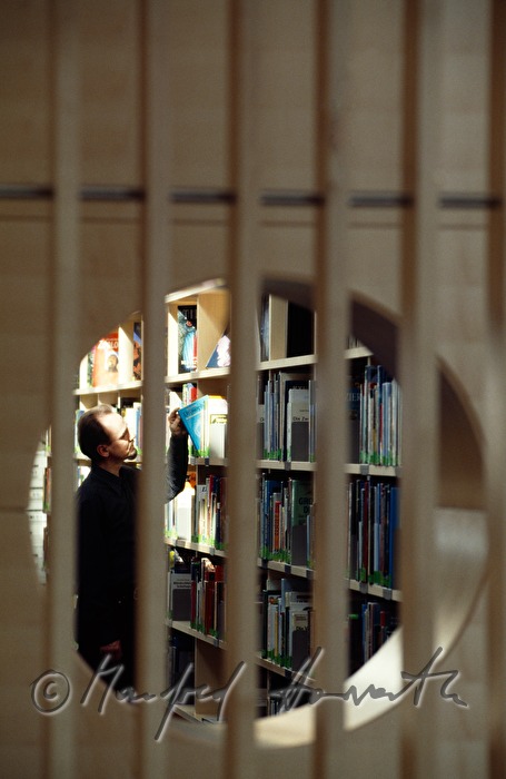 Besucher nimmt ein Buch aus dem Regal