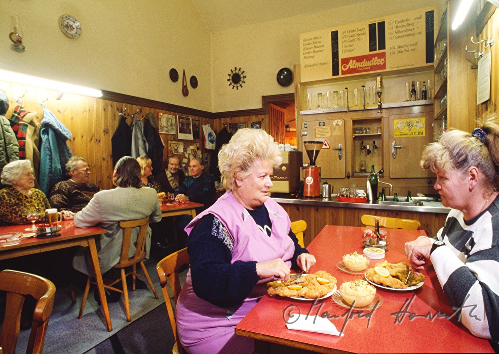 Betreiberinnen des Gasthauses essen Wiener Schnitzel