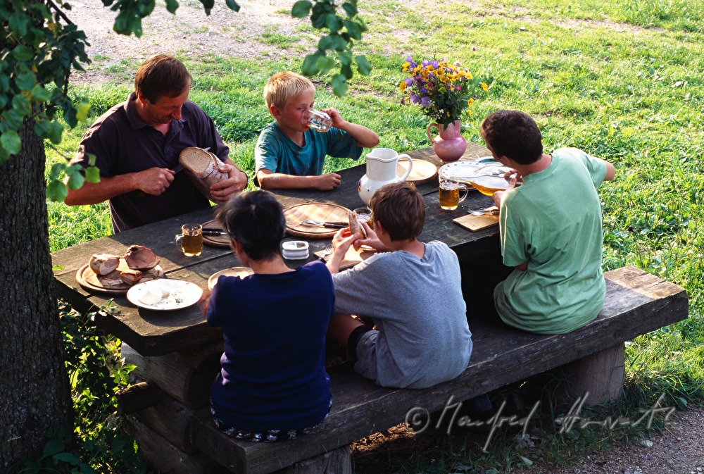 Bauern-Familie im Garten bei der Most-Jause