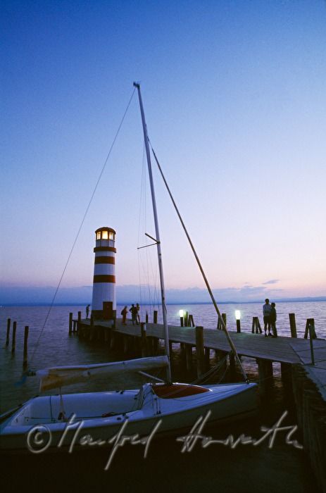 Leuchtturm, Segelboot und Steg mit Besuchern