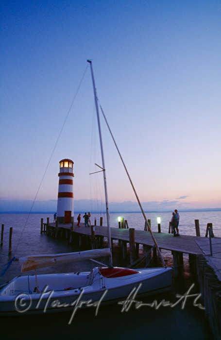 Leuchtturm, Segelboot und Steg mit Besuchern