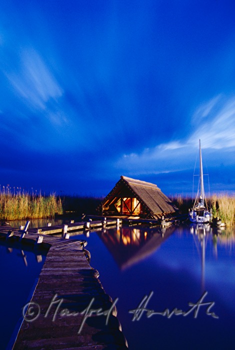 Seehütte mit Holzsteg und Segelboot