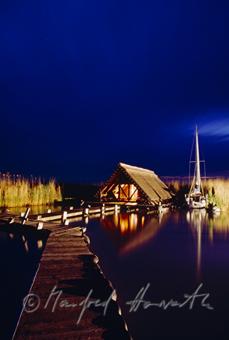 Seehütte mit Holzsteg und Segelboot