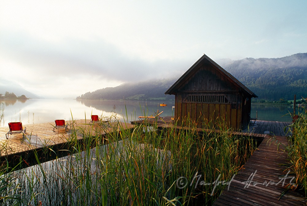Badesteg mit Liegestühlen und Bootshaus