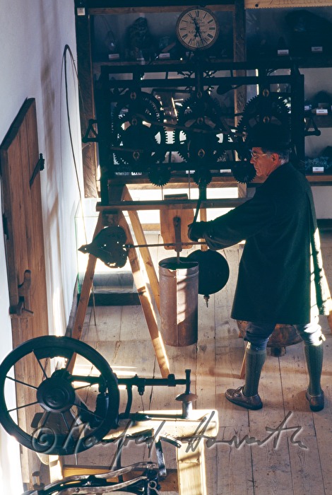 Museumsführer zieht ein Kirchenuhrwerk auf