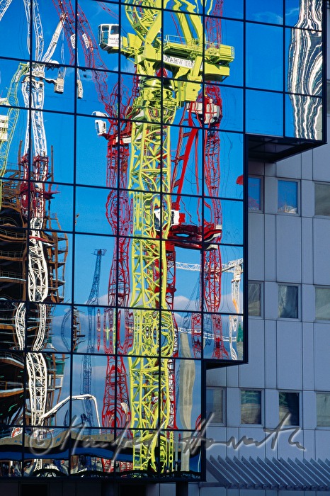 Hafen-Kräne spiegeln sich in Glasfassade