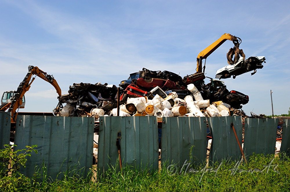 Bagger verladet Schrott auf Schrottplatz