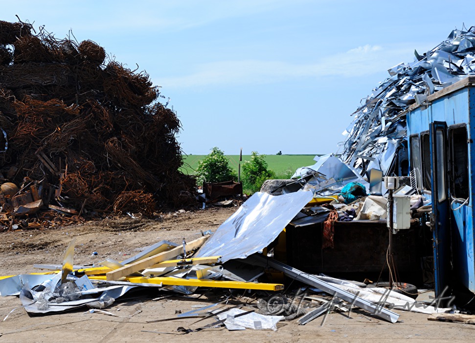Bagger verladet Schrott auf Schrottplatz