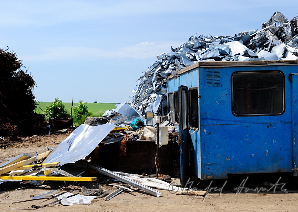 Bagger verladet Schrott auf Schrottplatz