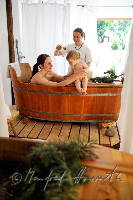 Frau nimmt ein Wellness-Latschen-Bad im Holzzuber