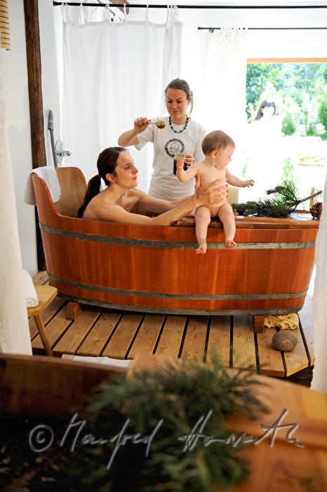 Frau nimmt ein Wellness-Latschen-Bad im Holzzuber