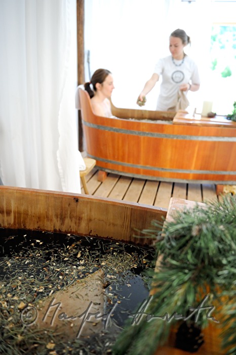 Frau nimmt ein Wellness-Latschen-Bad im Holzzuber