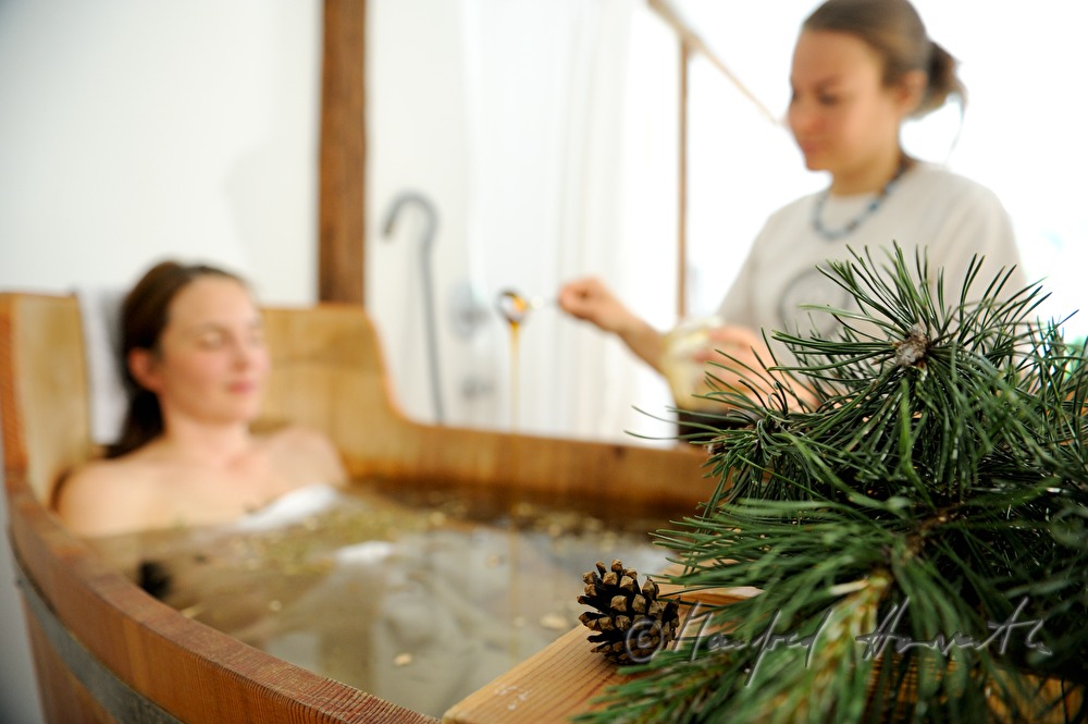 Frau nimmt ein Wellness-Latschen-Bad im Holzzuber