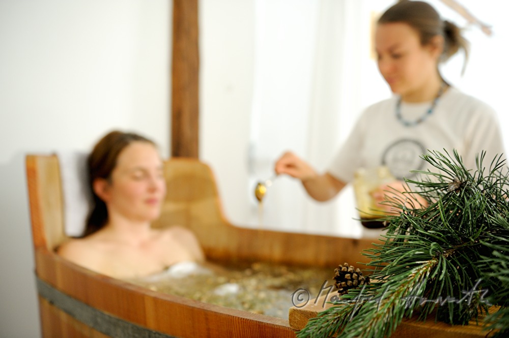 Frau nimmt ein Wellness-Latschen-Bad im Holzzuber