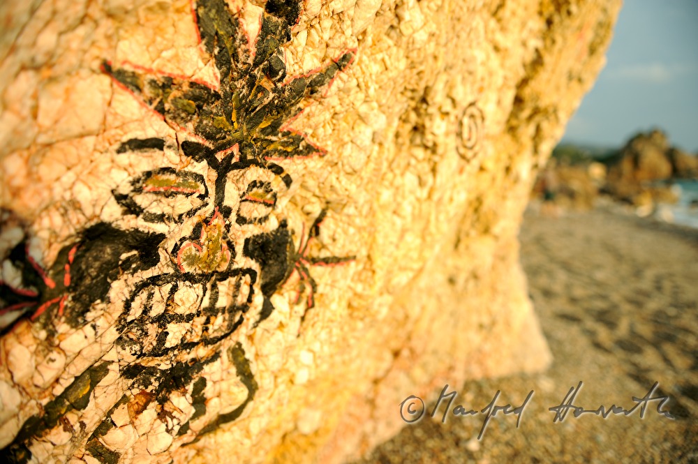 Graffiti an einem Felsen am Strand