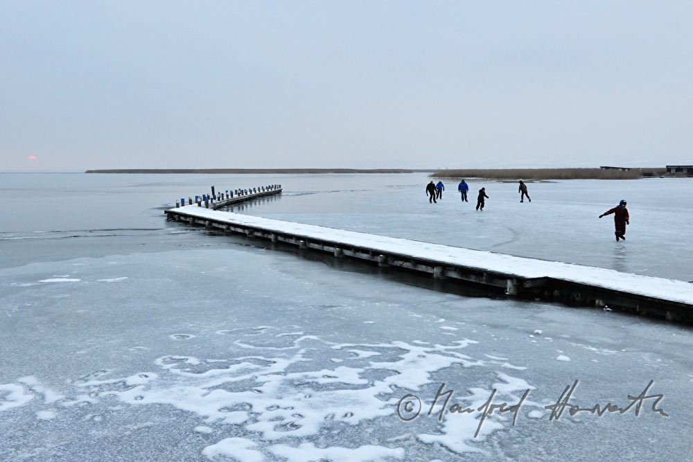 Steg und Eisläufer bei Sonnenuntergang