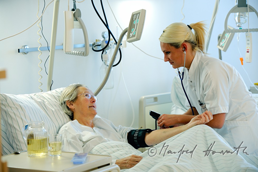 Schwester misst Blutdruck einer Patientin