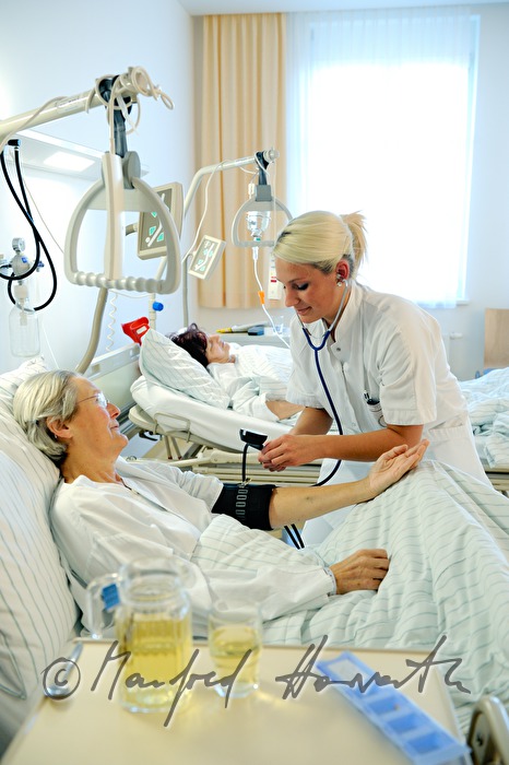 Schwester misst Blutdruck einer Patientin