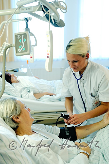 Schwester misst Blutdruck einer Patientin