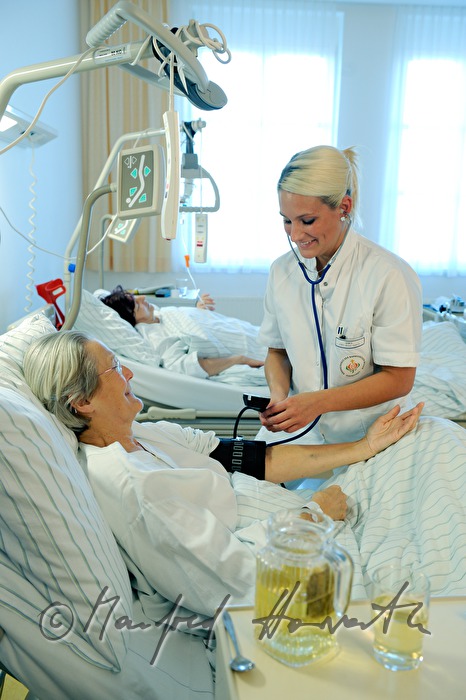 Schwester misst Blutdruck einer Patientin