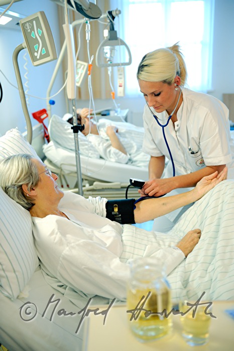 Schwester misst Blutdruck einer Patientin