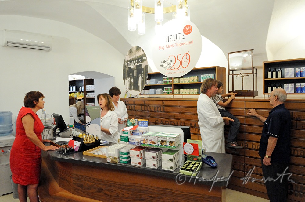Apotheker zeigt seinen Kunden die alte Waage