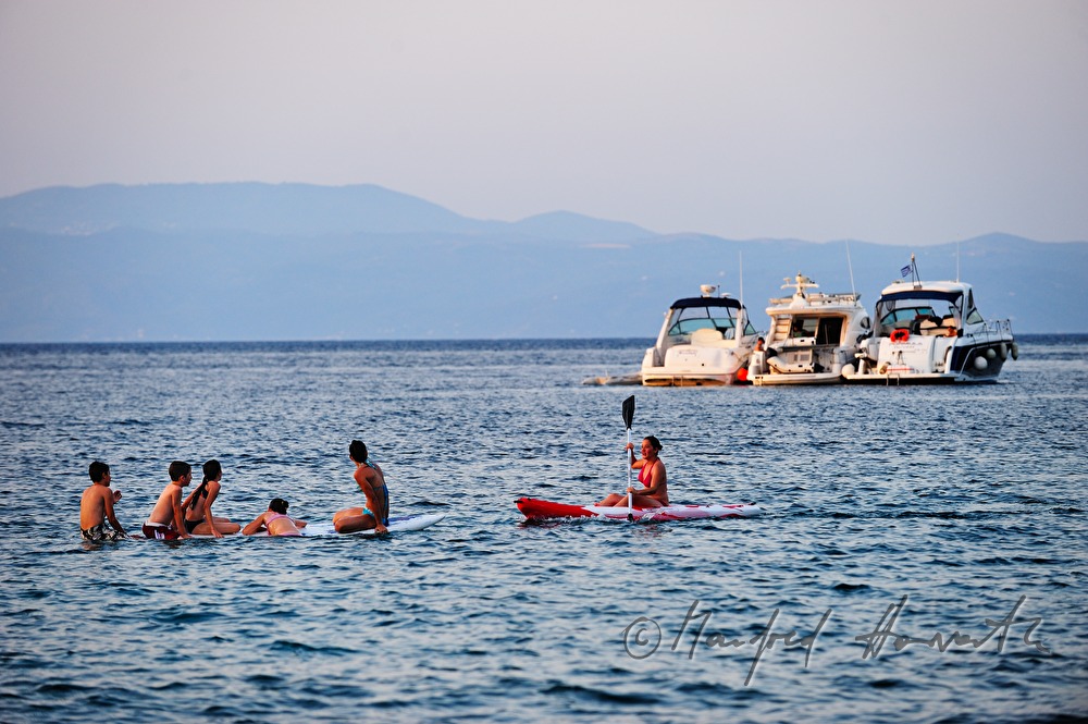 Wassersportler und Badende in der Bucht