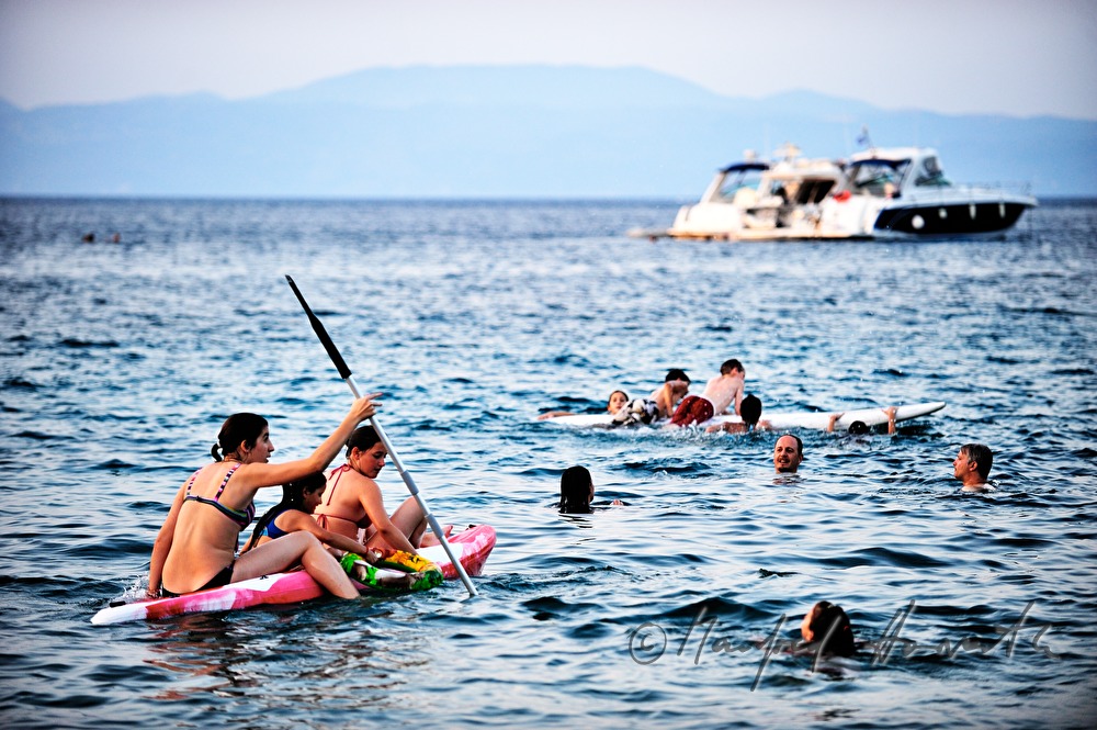 Wassersportler und Badende in der Bucht