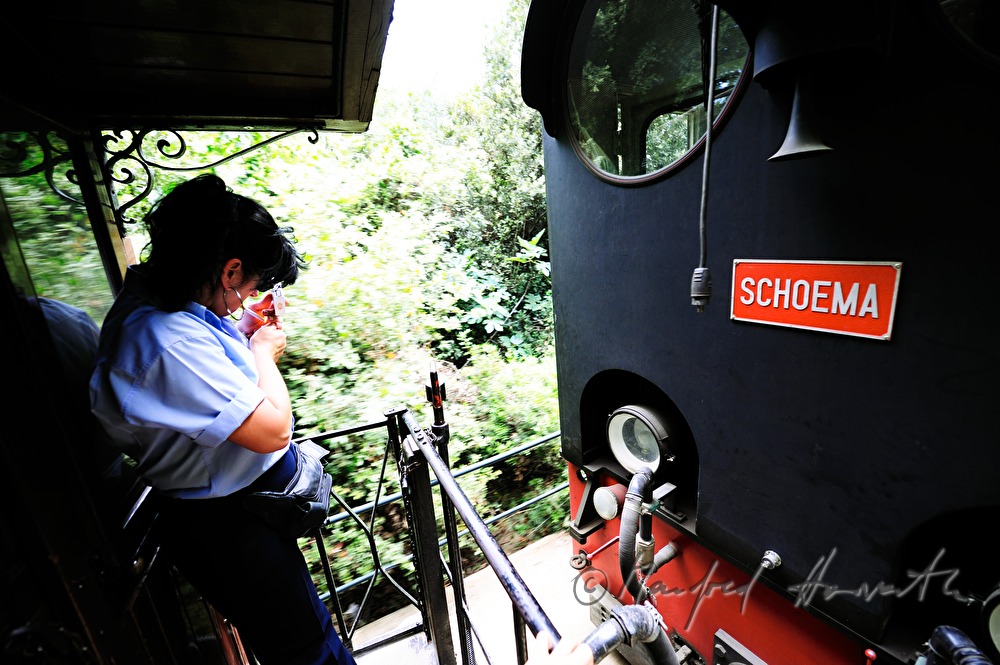 Schaffnerin der Pilionbahn raucht auf Plattform