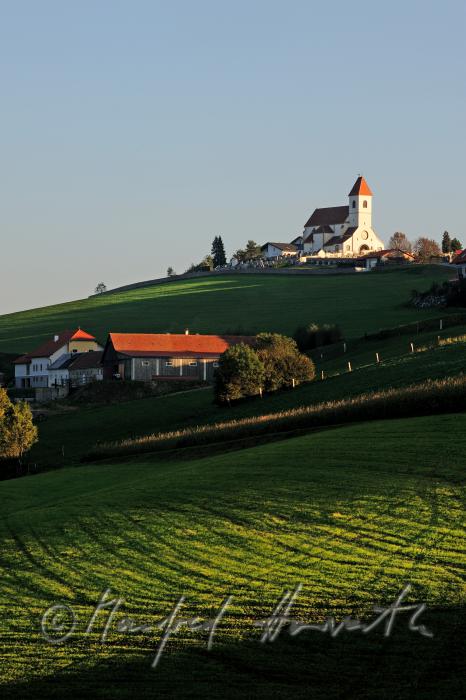 Wehrkirche, Bauernhof und Wiesen