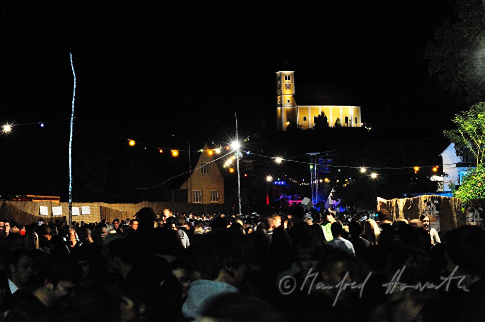Festivalgelände mit Besuchern unter der Kirche