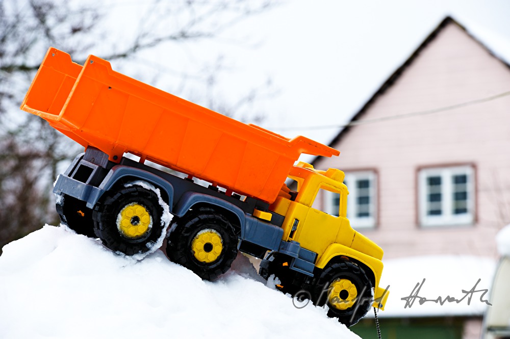 Spielzeuglastwagen auf einem Schneehaufen