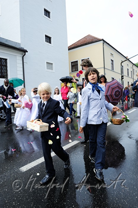 Kinder streuen Blütenblätter bei Fronleichnams-Prozession