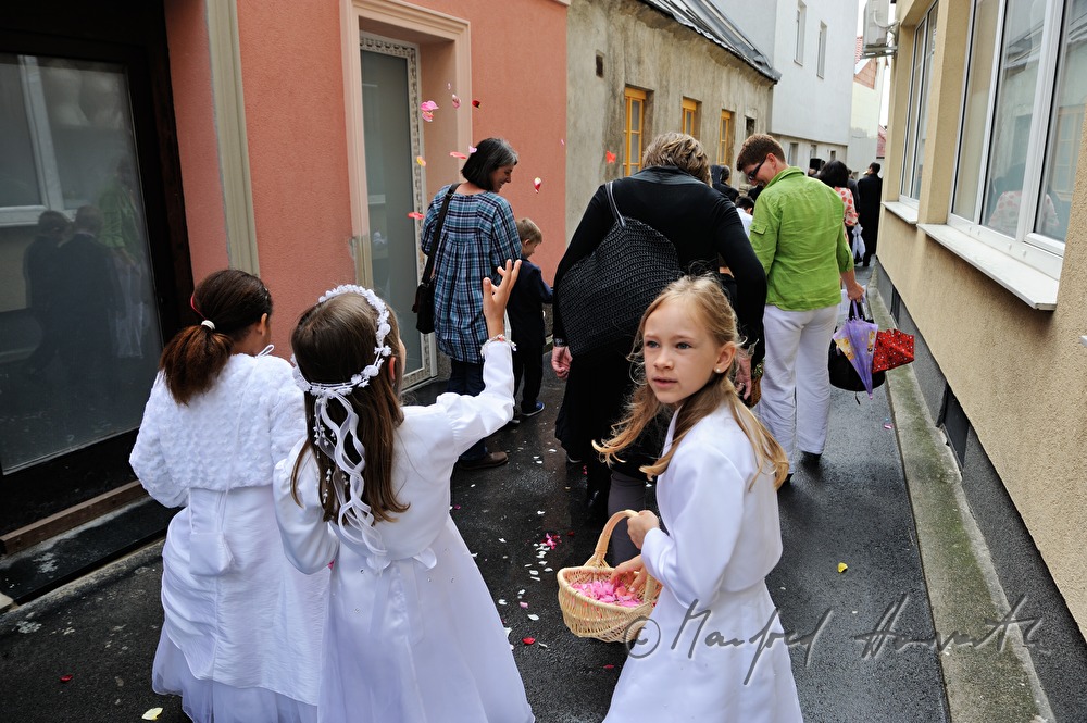 Kinder streuen Blütenblätter bei Fronleichnams-Prozession