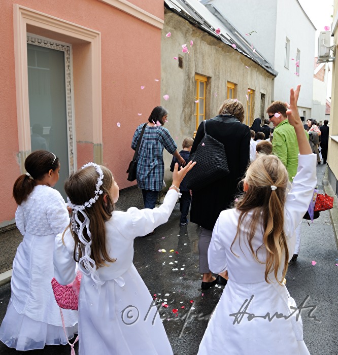 Kinder streuen Blütenblätter bei Fronleichnams-Prozession