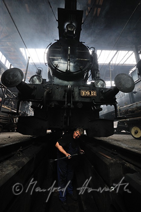 Lokomotivführer der Lokomotive 190.13 beim Schmieren der Achsen