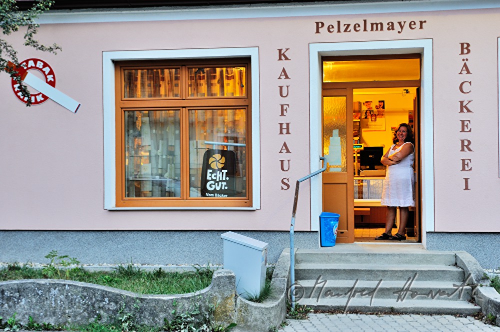 Verkäuferin vor ihrer Greisslerei