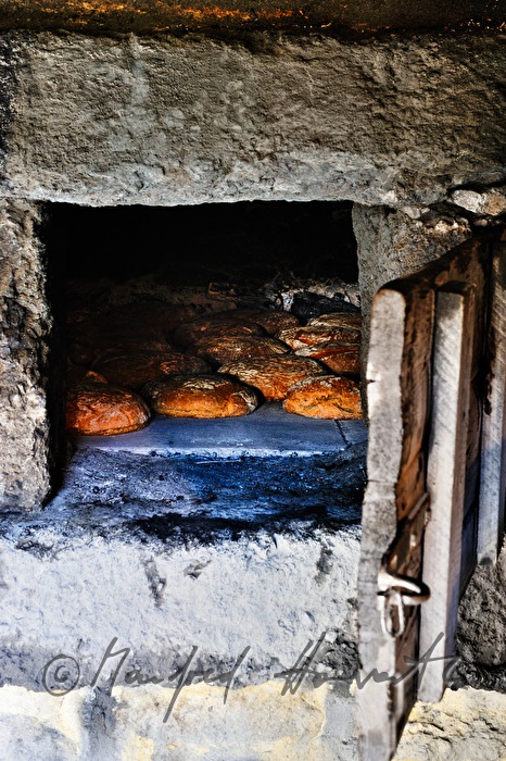 Backen von Holzofenbrot im feuerbetriebenen Backhaus
