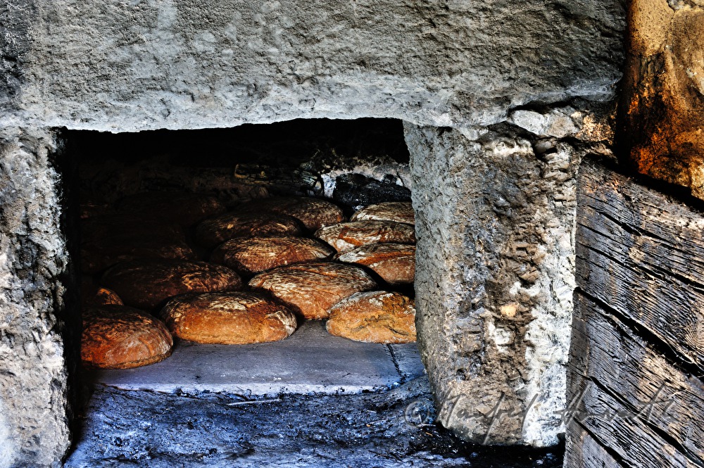 Backen von Holzofenbrot im feuerbetriebenen Backhaus
