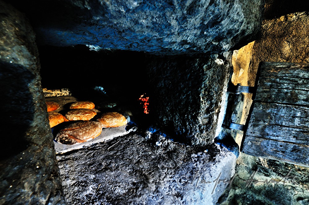 Backen von Holzofenbrot im feuerbetriebenen Backhaus