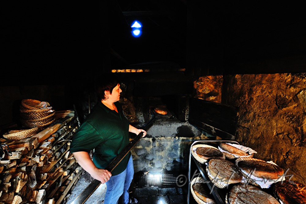 Backen von Holzofenbrot im feuerbetriebenen Backhaus