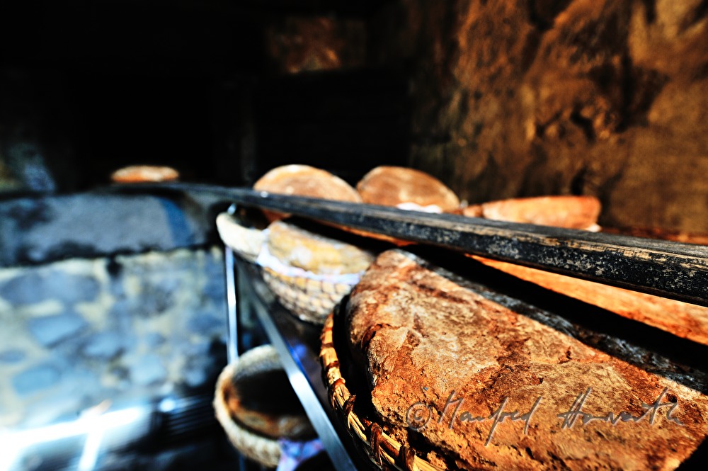 Backen von Holzofenbrot im feuerbetriebenen Backhaus