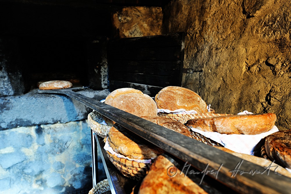 Backen von Holzofenbrot im feuerbetriebenen Backhaus
