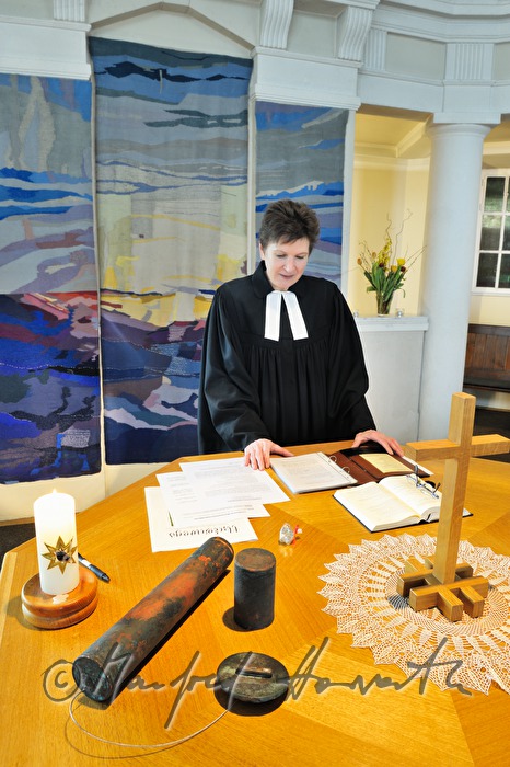 Pastorin beim Altar mit Zeitkapsel der Kirchturmspitze