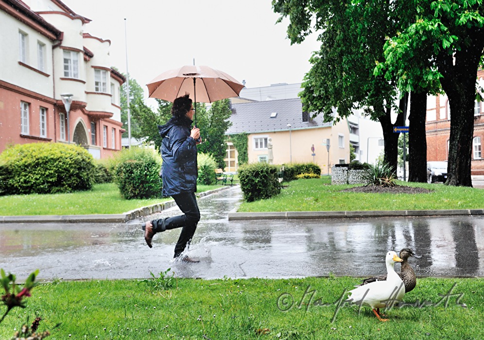 Frau läuft im Regen mit Regenschirm